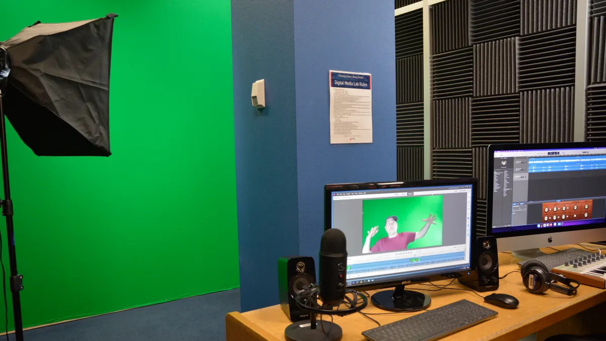 Digital Media Lab showing a green screen and two computer monitors