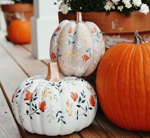 White pumpkins painted with vine decoration.