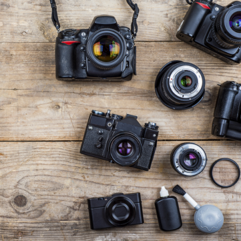 Various cameras on a wooden table