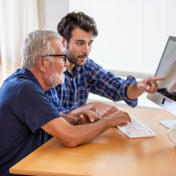 Young man and older man working together on a computer